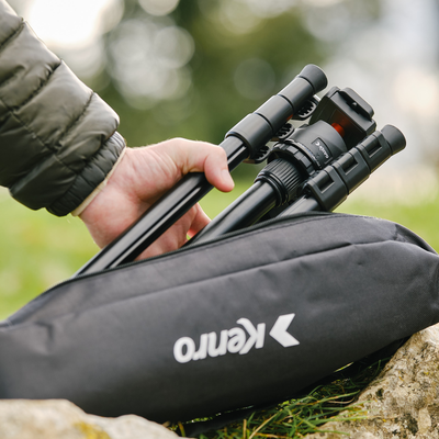 Hand taking a Kenro tripod out of a Kenro branded bag