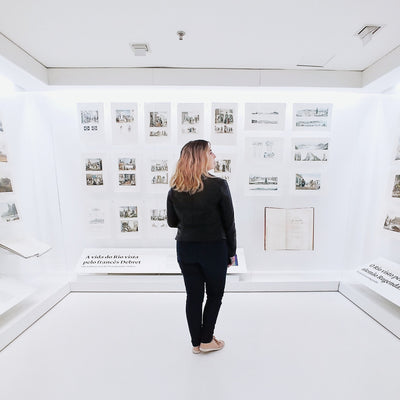 Lady dressed in black looking at photo exhibition with white walls