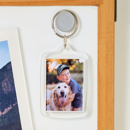 Whiteboard with various photos and notes attached, including a family photo and travel-themed images.