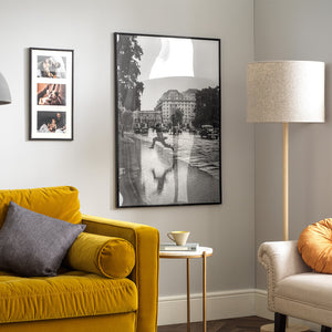 Frisco Plastic Photo and Poster Frames in Black shown in home with yellow sofa